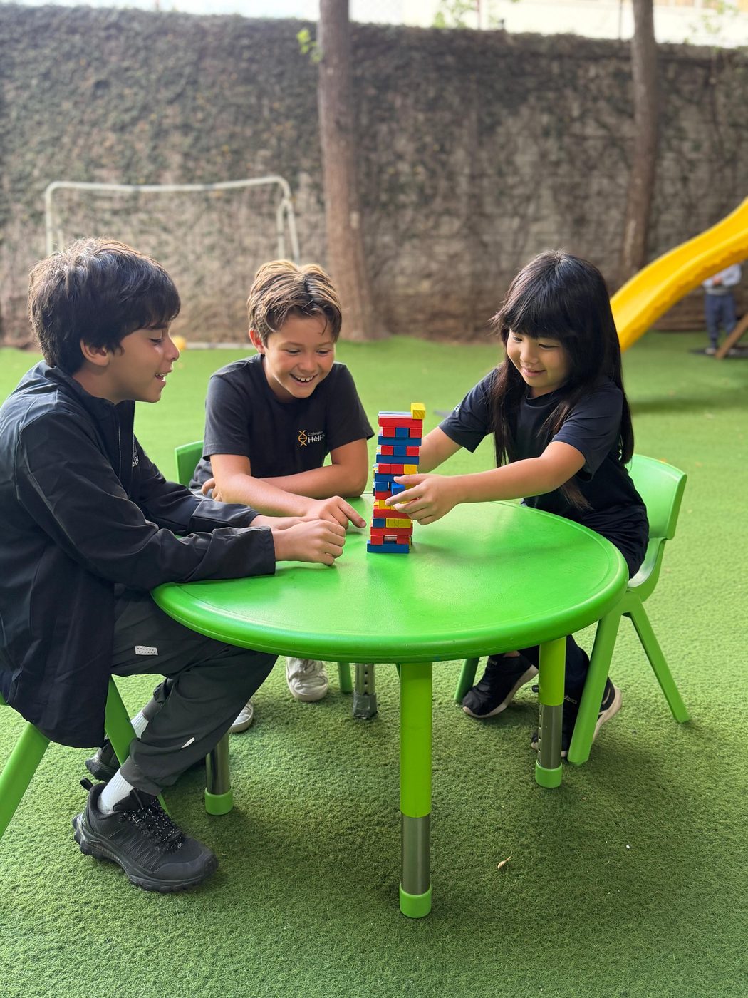 Alumnos de Colegio Hélice jugando con una torre de bloques